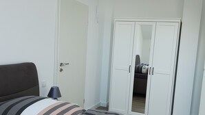 Une chambre à coucher avec un lit, une armoire et une porte.