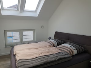A bedroom with a bed, a window, and a skylight. - Apartment Studio EifelGlückII with balcony (Sankt Johann)