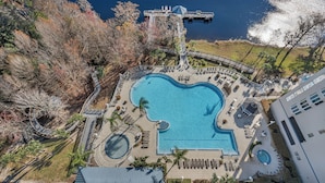 Luchtbeeld van een resort met een groot zwembad, een waterval en een brug die verschillende zones met elkaar verbindt.