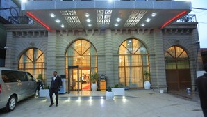 A hotel entrance with large arched windows, a modern design, and a well-lit facade.