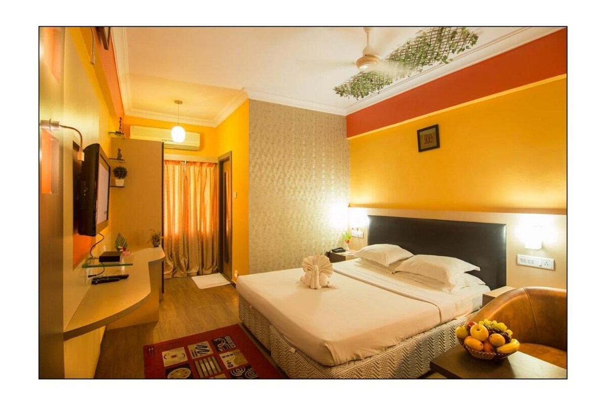 Una habitación de hotel con cama, mesita de noche y frutero.