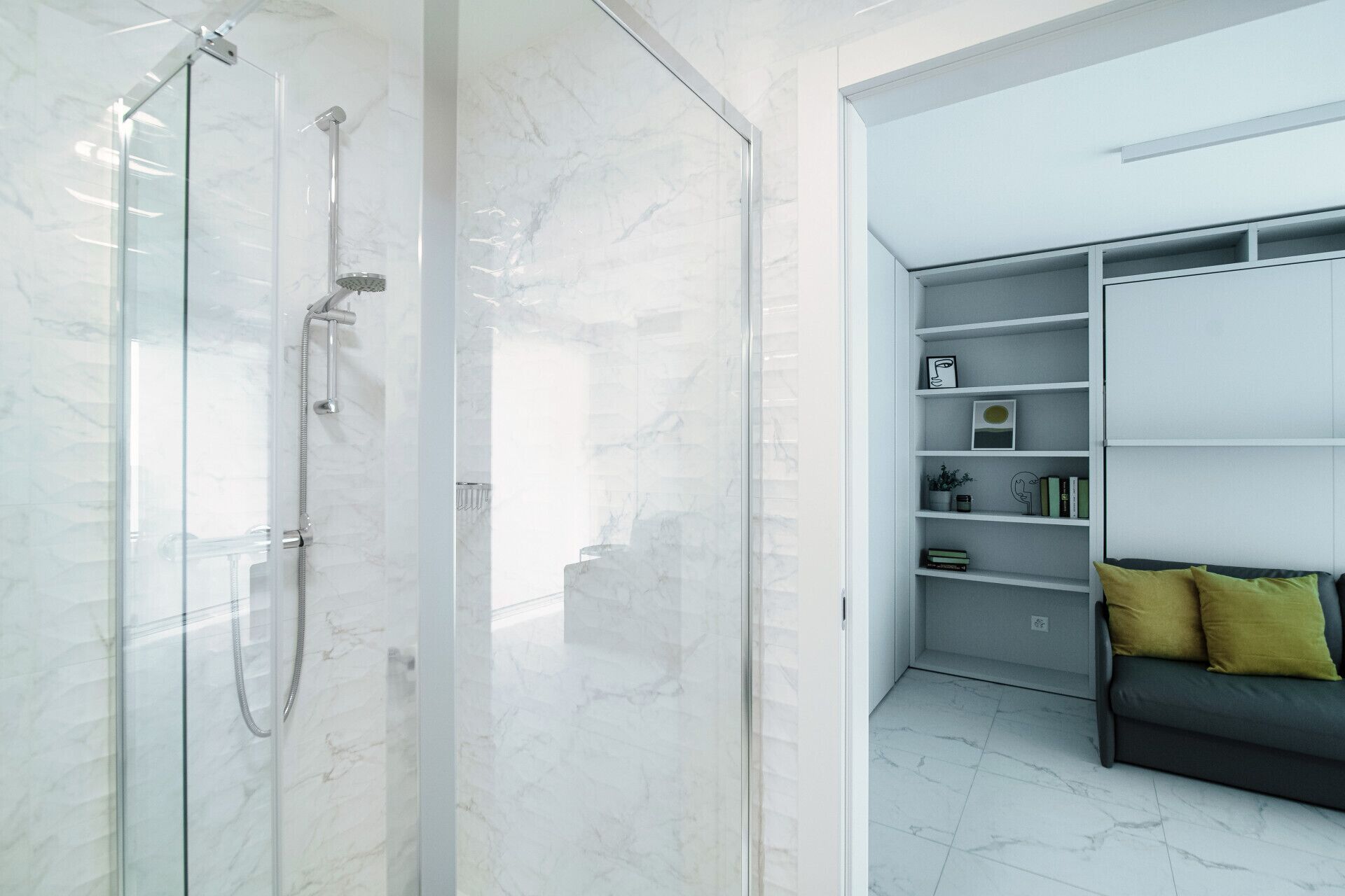 Ein modernes Badezimmer mit einer gläsernen Dusche und einer integrierten Regalkonstruktion mit Büchern und Dekoration.