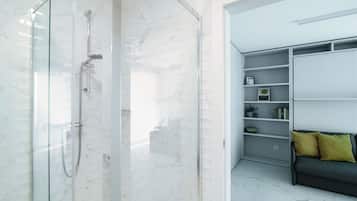 Ein modernes Badezimmer mit einer gläsernen Dusche und einer integrierten Regalkonstruktion mit Büchern und Dekoration.