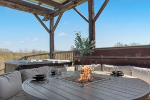 Une terrasse extérieure avec une table ronde, un foyer et des sièges.