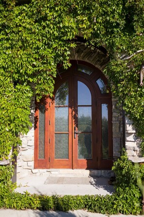 Un bâtiment en pierre doté d’une fenêtre en arc surmontée d’un arc en bois et d’une porte.
