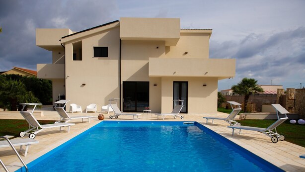 A modern two-story building with a swimming pool.