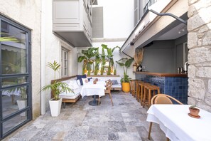 A cozy outdoor seating area with a white table, chairs, and potted plants. - Alle Alacati (Cesme)