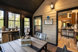 Un intérieur chaleureux comprenant un coin repas, une cuisine et une vue sur l’extérieur.