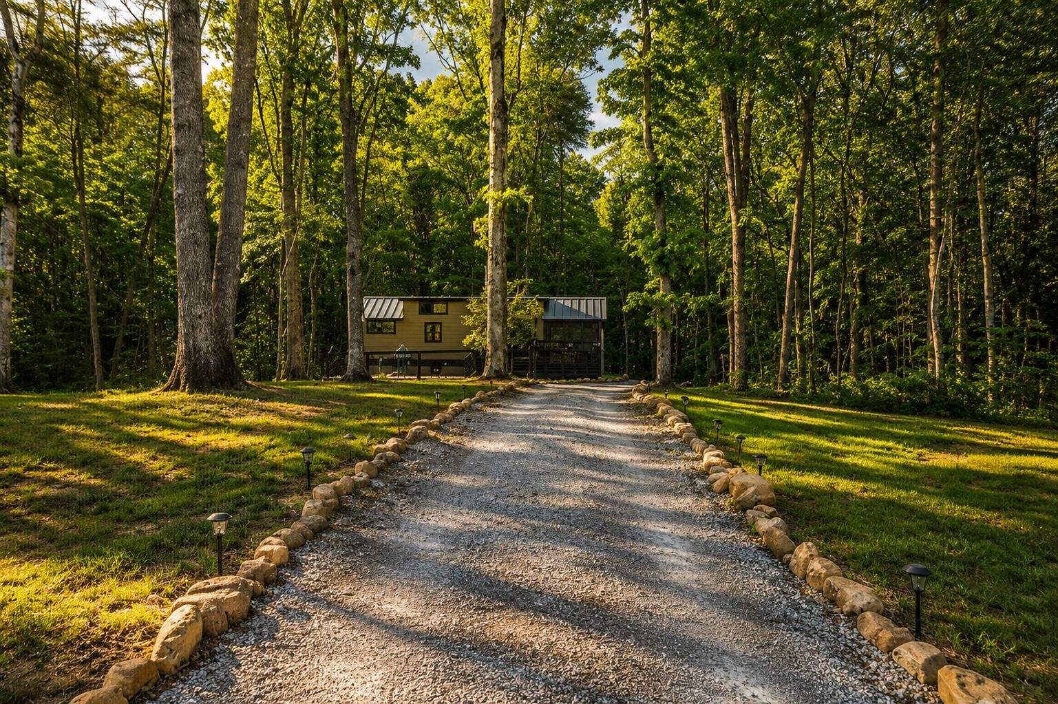 A gravel path leading to a cabin surrounded by trees.