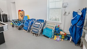 A room with multiple hospital beds, a window with blinds, a trash bin, and a blue umbrella. - White Sands Retreat - Pool/Hot Tub/Walk to Beach! (St. Augustine Beach)