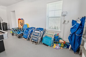 A room with multiple hospital beds, a window with blinds, a trash bin, and a blue umbrella. - White Sands Retreat - Pool/Hot Tub/Walk to Beach! (St. Augustine Beach)