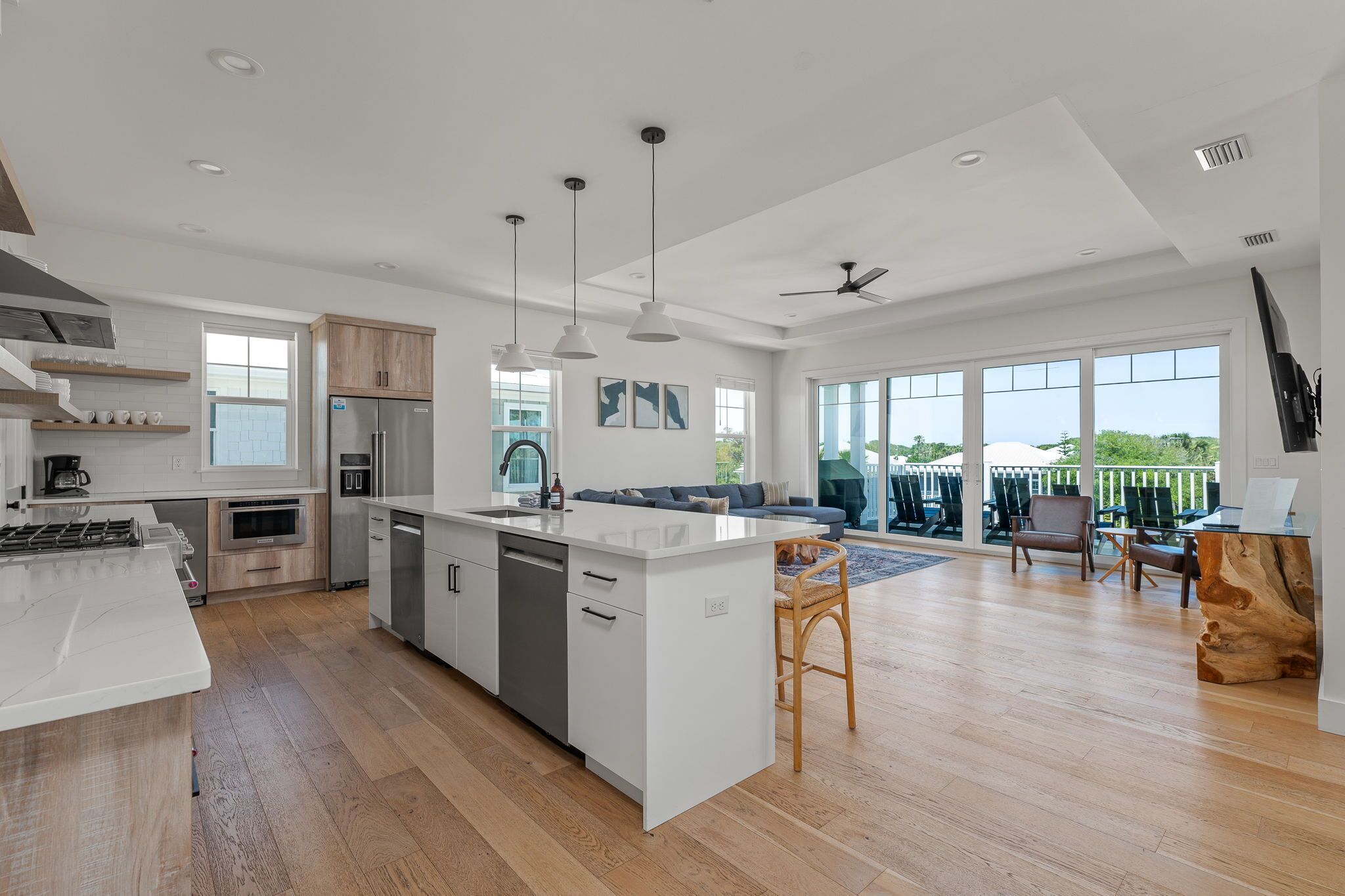 A modern kitchen with a central island, built-in appliances, and pendant lighting.