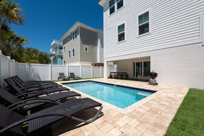 A swimming pool with lounge chairs, a barbecue grill, and a covered patio area. - White Sands Retreat - Pool/Hot Tub/Walk to Beach! (St. Augustine Beach)