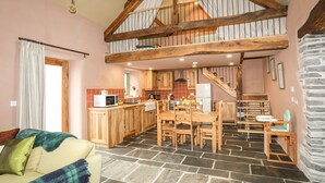 Eine geräumige Küche mit Holzausstattung, ein Essbereich mit Tisch und Stühlen sowie eine Treppe, die in ein Obergeschoss führt.