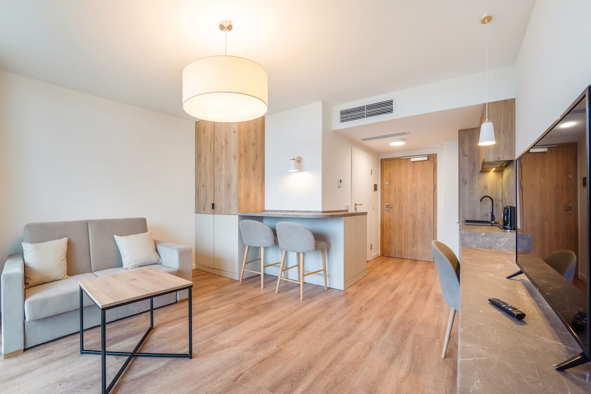 Un salon moderne avec un canapé, une table basse et un coin cuisine doté d’un bar.