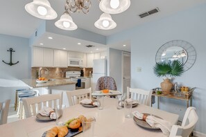 Enjoy meals in this inviting dining area with a modern kitchen and comfortable seating.
