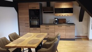 A modern kitchen with wooden cabinets, a built-in oven, and a coffee maker. - 1 Bedroom Apartment in Klein Upahl (Klein Upahl)