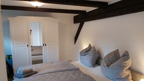 A bedroom with two beds, a wardrobe, and a nightstand with a lamp. - 1 Bedroom Apartment in Klein Upahl (Klein Upahl)