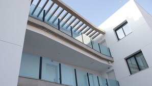 A modern building with a glass balcony and multiple windows. - Azahar Beach Apartments (Alcala de Xivert)