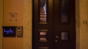 Entrada de hotel con puerta de madera oscura, mostrador de recepción y un letrero que dice "bugalha my loft".