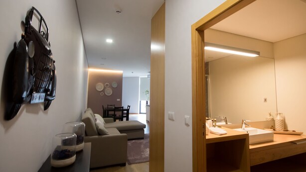 A modern bathroom with a large mirror, wooden vanity, and a sink.