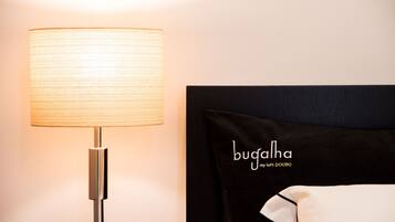 A bed with a black headboard and a pillow with the text "bugalha my loft DOURO".