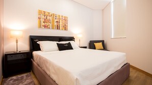 A neatly arranged hotel room with a large bed, two bedside tables, and a wall-mounted artwork.