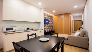 A compact living space with a kitchenette, a dining area, and a sofa.