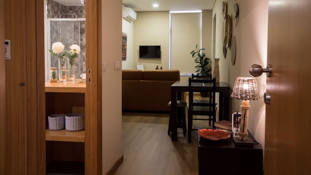 A modern living room with a wooden cabinet, a dining table, and a sofa. - Bugalha My Loft Douro 8 (Peso da Régua)