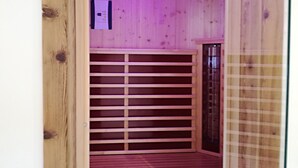 A wooden interior with a built-in closet featuring sliding doors and a small shelf unit. - Ferienhaus mit Sauna am Waldrand (Kärnten)