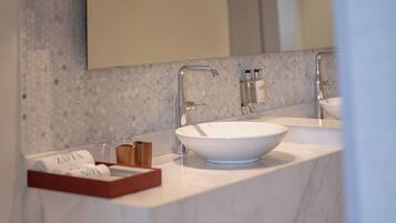 Une salle de bain moderne avec un comptoir en marbre, deux lavabos et un grand miroir.