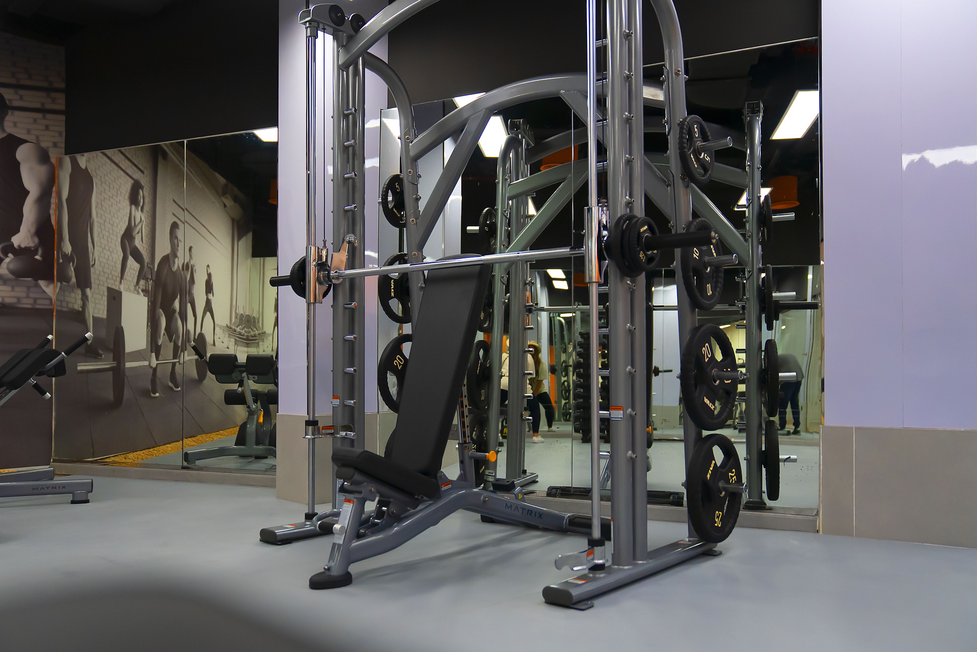 Ein Fitnessraum mit Gewichte, Laufband und Spiegelwand.