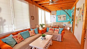 A cozy living room with a curved sofa, a coffee table, and a dining area with a table and chairs. - Vacation apartment CASA LA ISLA, Tarajalejo, fiber optic internet (Tarajalejo)