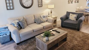A living room with a sofa, armchair, coffee table, and decorative items. - Ocean view flat, poolside ( ground floor). Two  bedrooms, two baths. (St. Augustine)