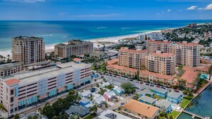A coastal cityscape with high-rise hotels, a beach, and a marina. - Frenchy’s Cottage 480 in Clearwater Beach (Clearwater Beach)