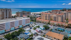A coastal cityscape with high-rise hotels, a beach, and a parking area.