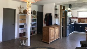 A spacious living area with a wooden cabinet, a bookshelf, and a hanging light fixture. - Family home between lake, ocean and Bassin d'Arcachon (La Teste-de-Buch)