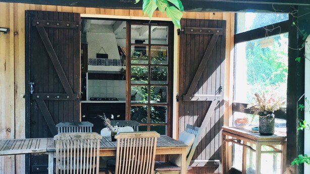 A wooden deck with a table and chairs, a hanging plant, and a view of the interior through a glass door. - Family home between lake, ocean and Bassin d'Arcachon (La Teste-de-Buch)