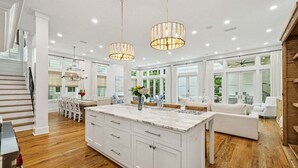 A spacious kitchen with a large island, white cabinetry, and pendant lighting. - President`s Row in WaterColor with Heated Pool, LSV, Bikes! STEPS to BEACH CLUB! RENOVATED 2025! (Santa Rosa Beach)