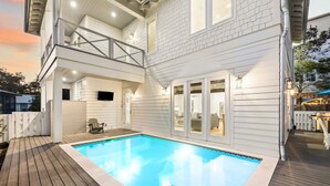 Une maison moderne dotée d’une piscine, d’une terrasse couverte et d’un balcon.