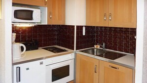 A compact kitchen with a microwave, stove, sink, and a small refrigerator. - Ski-in/ski-out & foot of the slopes, 5th floor, balcony, tv, 33m², Les Orres (Les Orres)
