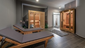 Un cuarto de spa con mesas de masaje de madera, una sauna y un armario de madera con estantes.