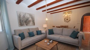 Una sala de estar con dos sofás, una mesa de centro, una lámpara y un cuadro en la pared.