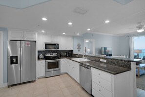 Enjoy ocean views from this kitchen with a large window, stainless steel appliances, and granite countertops.