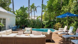 A poolside area with wicker furniture, a dining table, and chairs. - **SOUTHERNMOST BLISS @ OLD TOWN** Home & Pool + Last Key White Glove Service... (Key West)