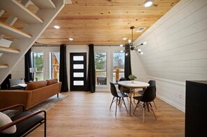 Relax in a spacious room with a cozy seating area, sofa, and chairs, featuring a large window and door to an outdoor space.