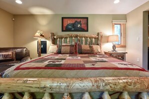 A bedroom with a large bed, a wooden headboard, a quilt, a framed picture on the wall, and a lamp on a side table. - Modern Home in the Mountains- within walking distance to ski slopes! (Somerset)