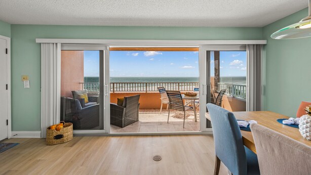 Ein Zimmer mit einer Schiebetür zu einem Balkon mit Meerblick.
