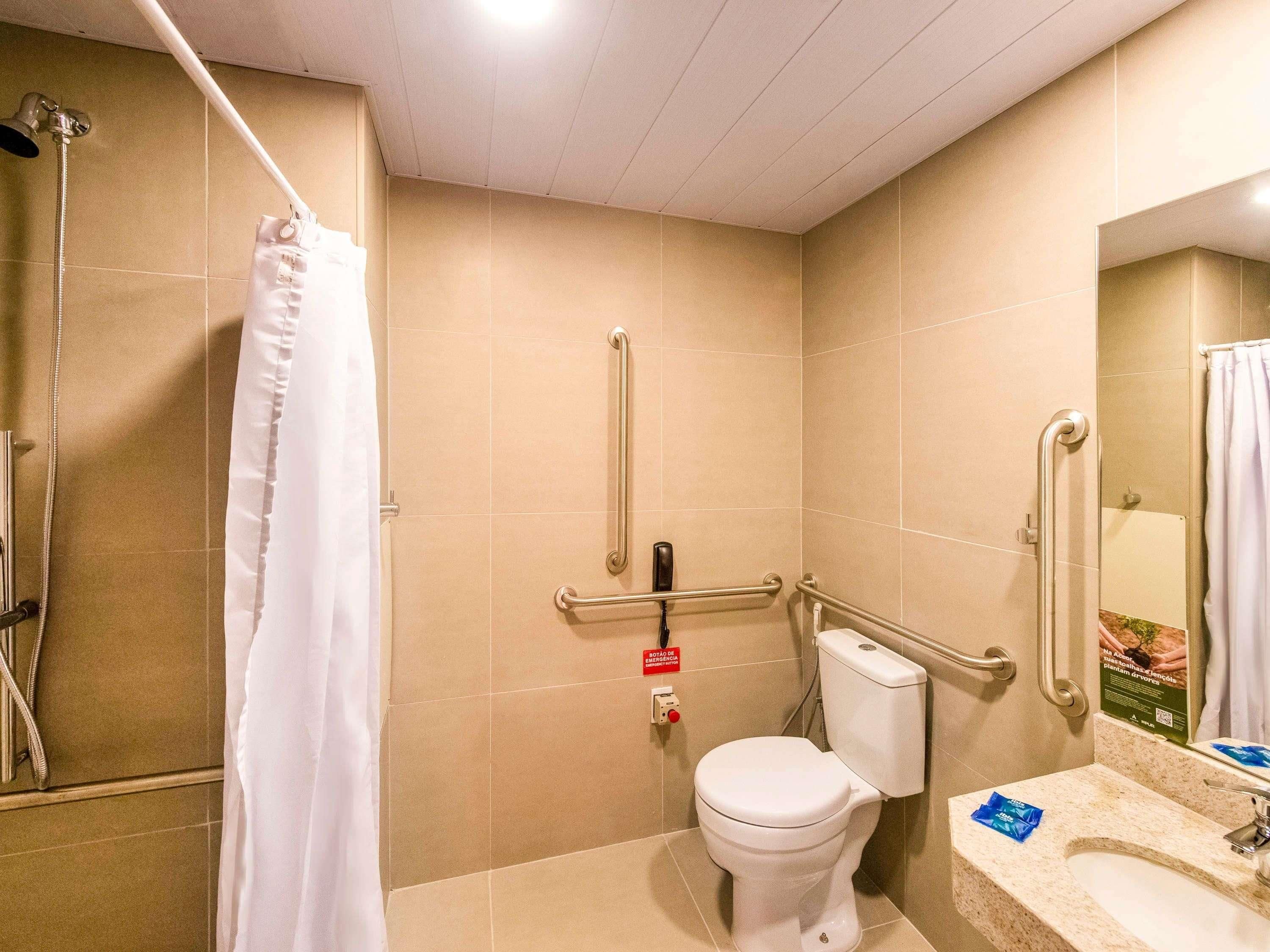 A bathroom with a shower, toilet, and sink.