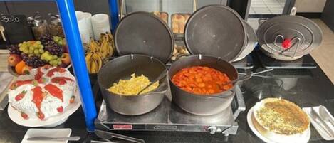 A buffet table with various dishes including a salad, rice, and a casserole.